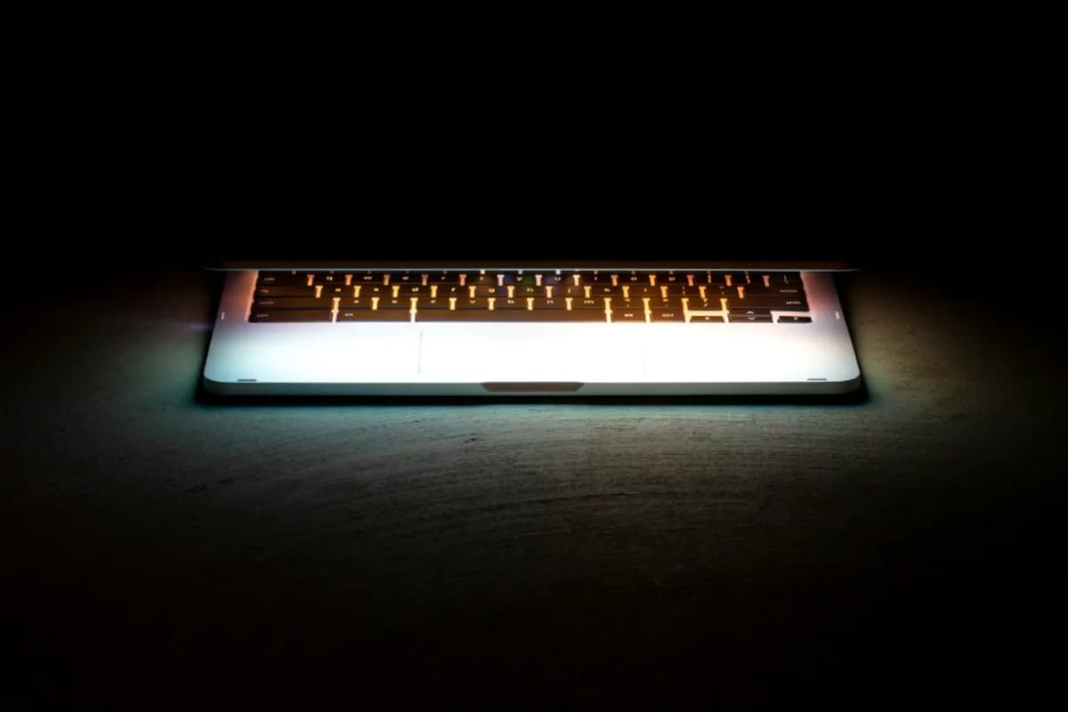 Glowing laptop on a dark desk
